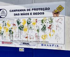 Painel da Campanha da Proteção das Mãos e Dedos que visa alertar sobre os cuidados e a utilização de luvas nas atividades nas obras da Ponte de Guaratuba