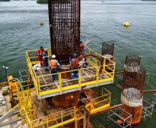 Obras da Ponte de Guaratuba chegam a 32% de execução e marcam progresso no trecho estaiado. Foto mostra oito estacas concluídas e trabalhadores colocando a armadura de aço para a concretagem