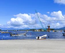 obras das ponte de guaratuba, barcos de pesca na praia de caieiras, baía de guaratuba com céu azul com nuvens, mar calmo e azul, 