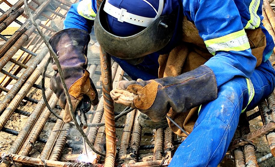 trabalhador da ponte de guaratuba realizando solda de ferragem fazendo uso de epi