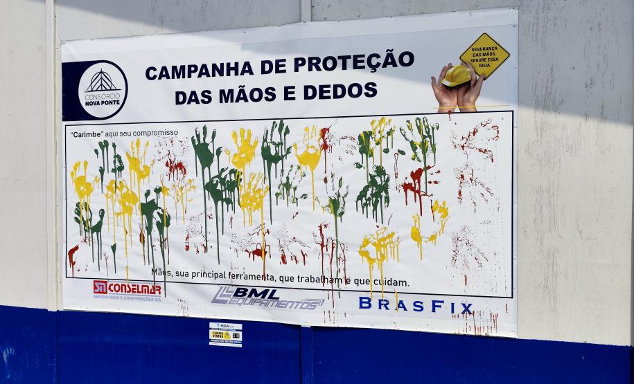 Painel da Campanha da Proteção das Mãos e Dedos que visa alertar sobre os cuidados e a utilização de luvas nas atividades nas obras da Ponte de Guaratuba
