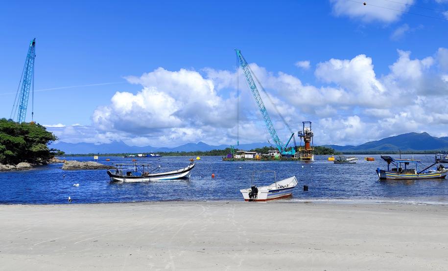 obras das ponte de guaratuba, barcos de pesca na praia de caieiras, baía de guaratuba com céu azul com nuvens, mar calmo e azul,